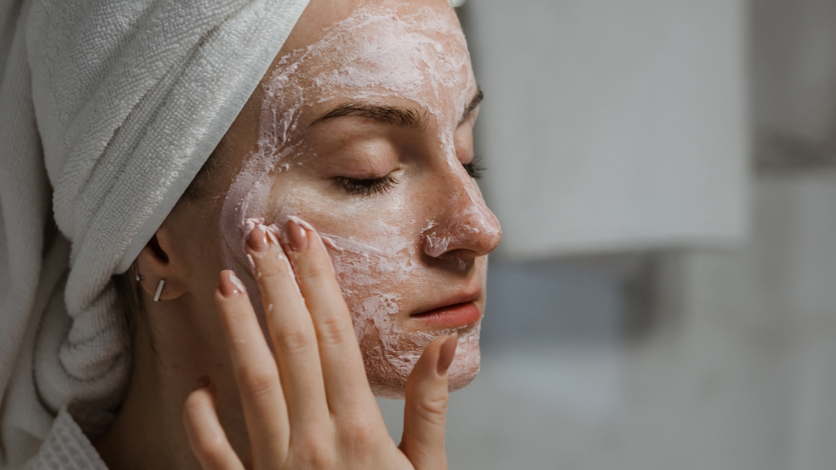 woman applying exfoliation treatment on her face as part of a skincare routine