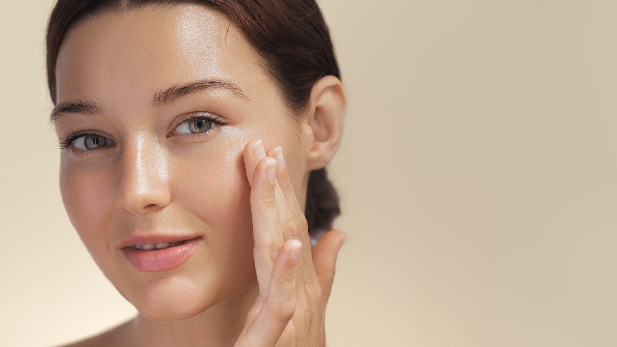 woman with healthy skin barrier touching her cheek and showing a hydrated glow