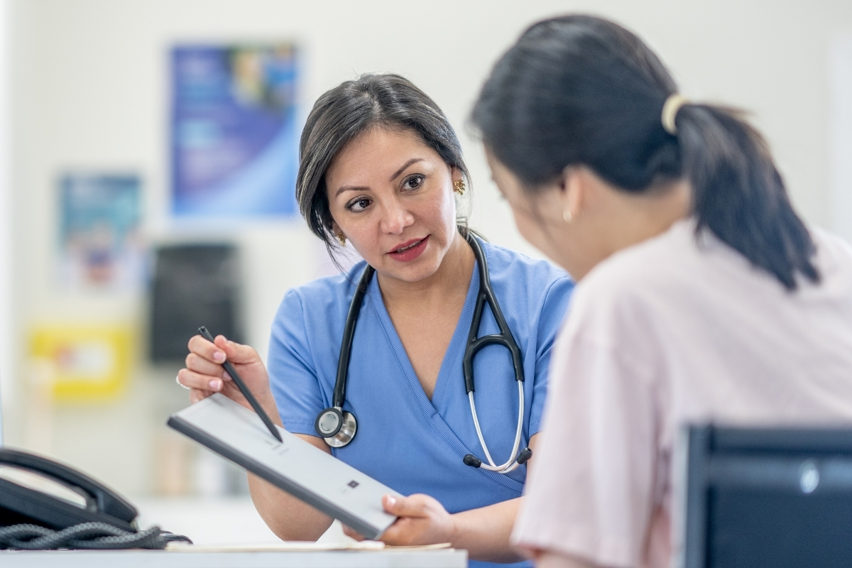 Healthcare professional discussing private sexual health test results with patient in clinic setting