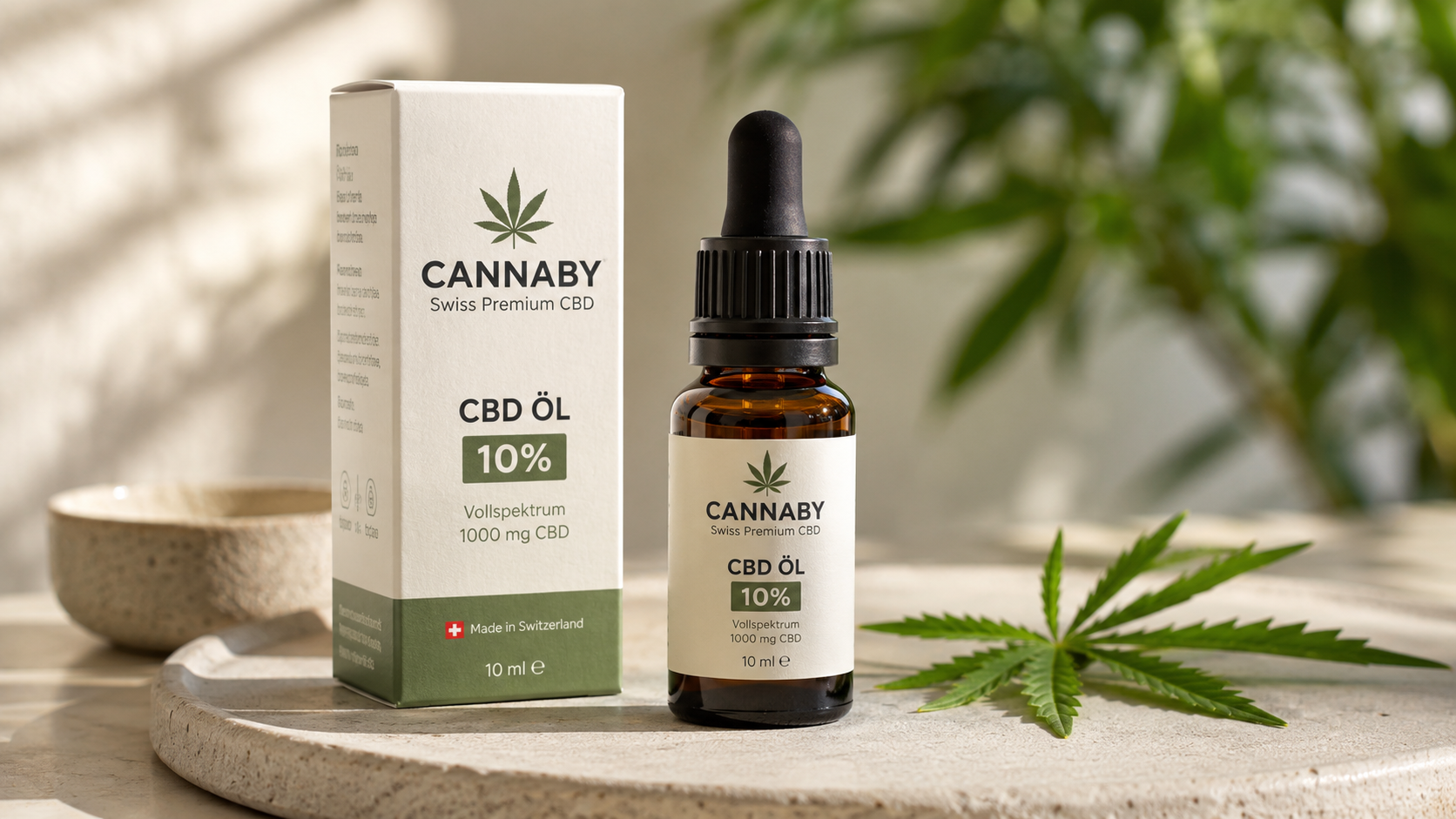 CANNABY CBD Öl 10% full-spectrum CBD oil bottle and packaging on a stone tray with a hemp leaf in a natural, sunlit setting, highlighting Swiss-made premium CBD oil.