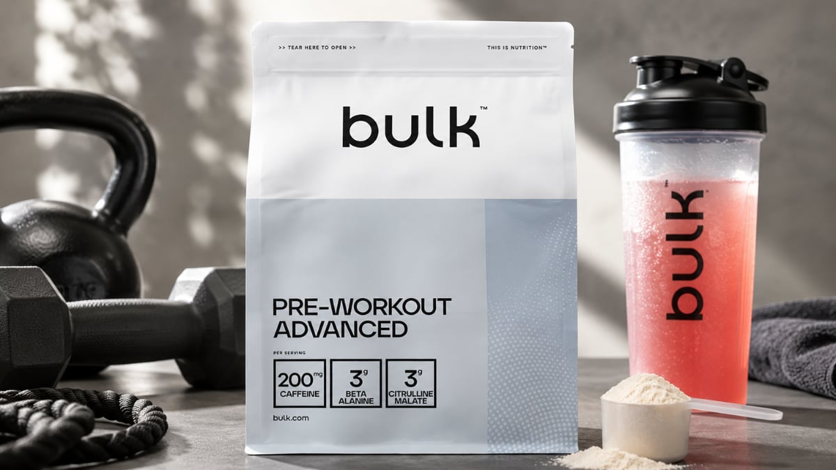 "Bulk Pre-Workout Advanced powder container with scoop beside mixed pre-workout drink, highlighting a high-stimulant workout supplement for energy, endurance, strength, and focus."